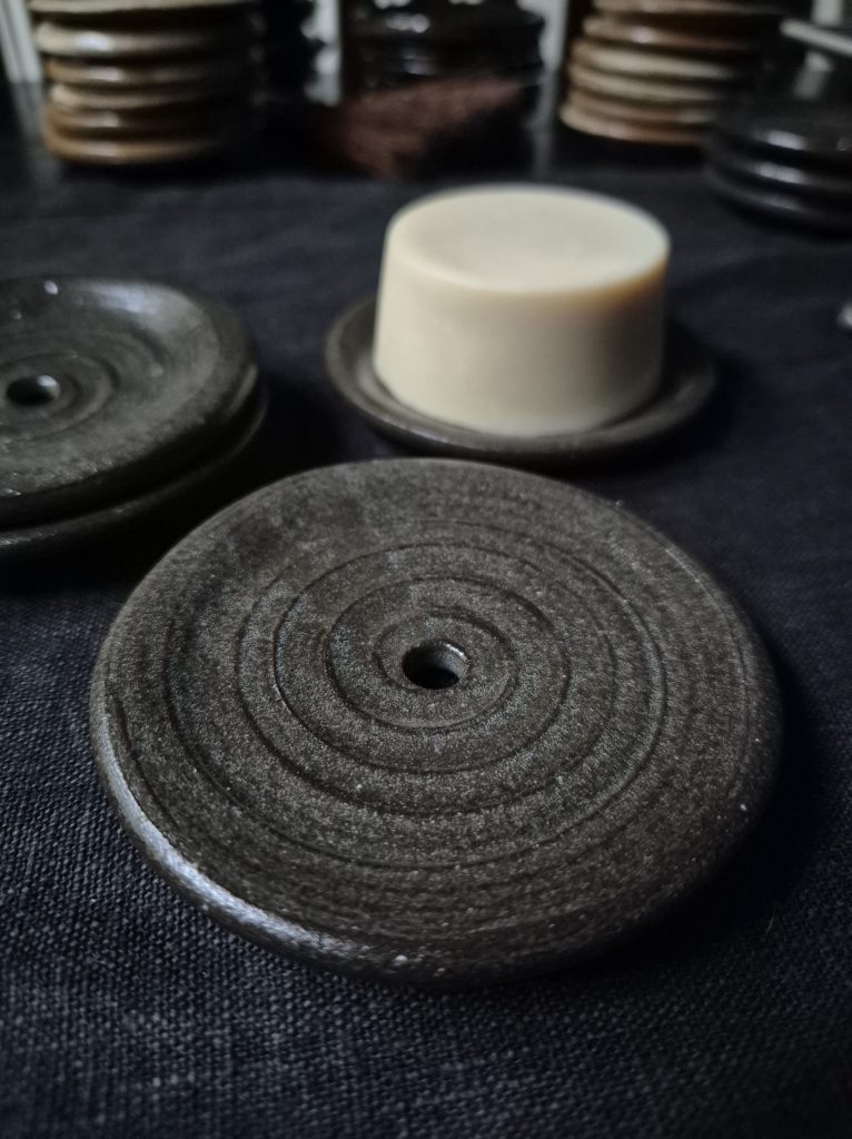Svart lergods med klar glasyr. Ca 8–9 cm i diameter. 195 kr.